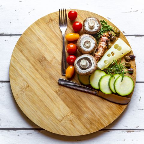 a wooden cutting board with vegetables and meat
