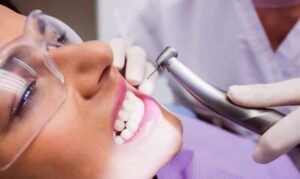 a woman is getting her teeth cleaned by a dentist